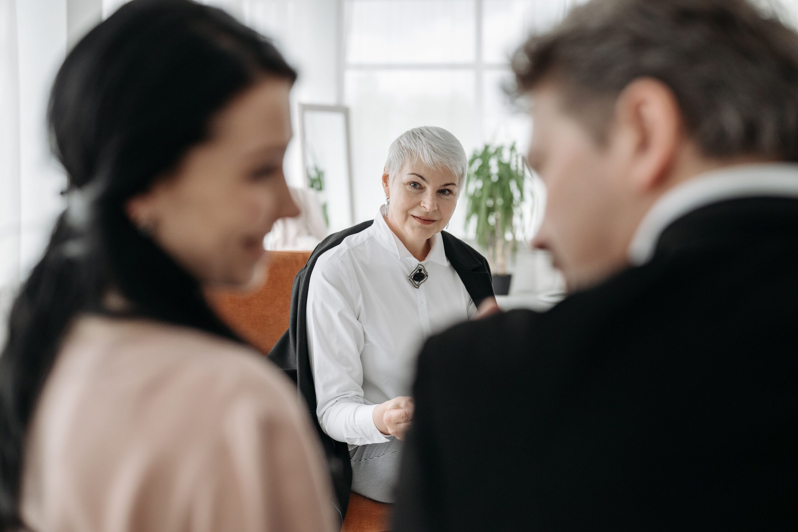 A professional consultation session with a couple and a social worker in a modern office environment.