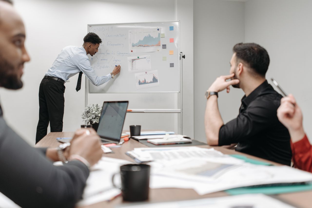 Colleagues in a business meeting discussing data and strategies at the office.